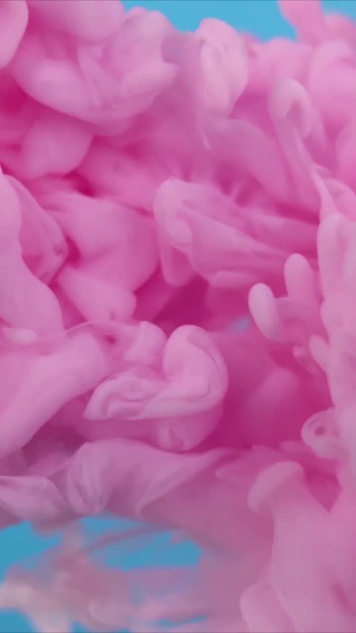 Nuvola di inchiostro rosa astratta che si diffonde in acqua blu