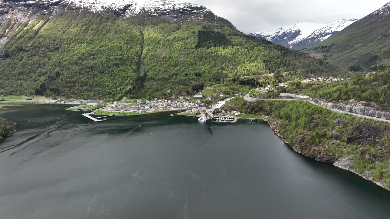 vista panorámica de hellesylt cerca del fiordo de geiranger en noruega - vista aérea de la primavera con un paisaje verde exuberante y montañas cubiertas de nieve