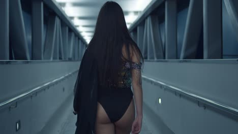 amazing latina walks in an overpass at night in a sparkle dress before turning around in a bikini bottom