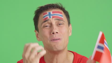 very nervous man supporting norwegian team during a difficult match