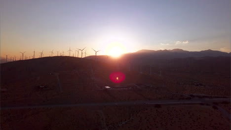 revealing aerial shot of wind turbines at sunset in southern california - energy production