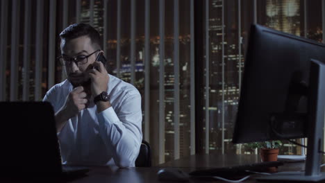 businessman working late at night in office, making a phone call