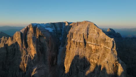 aerial view of gold lighting brenta dolomites mountains during golden sunset in italy