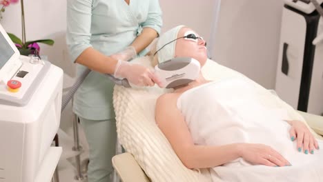 elos skin rejuvenation procedure. female with cooling gel and laser protection glasses in the modern cosmetology clinic. hardware cosmetology