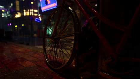 a red bicycle parked on a wet city street at night