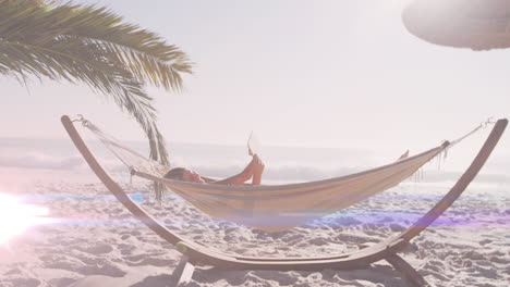 animación de puntos de luz sobre una mujer caucásica acostada en una hamaca en la playa