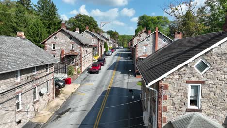 american flag on colonial stone house in miners village in usa town