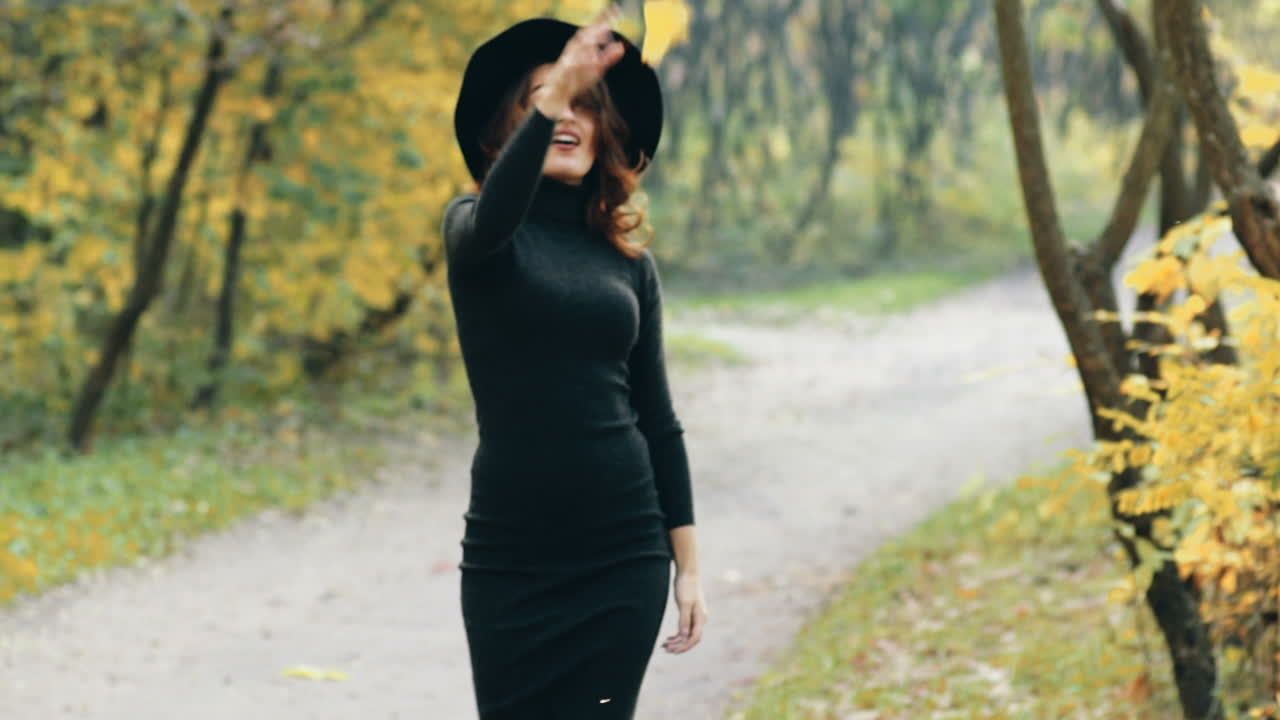 Elegant woman walking in a park. Beautiful elegant woman walking in a park in autumn , Fall concept