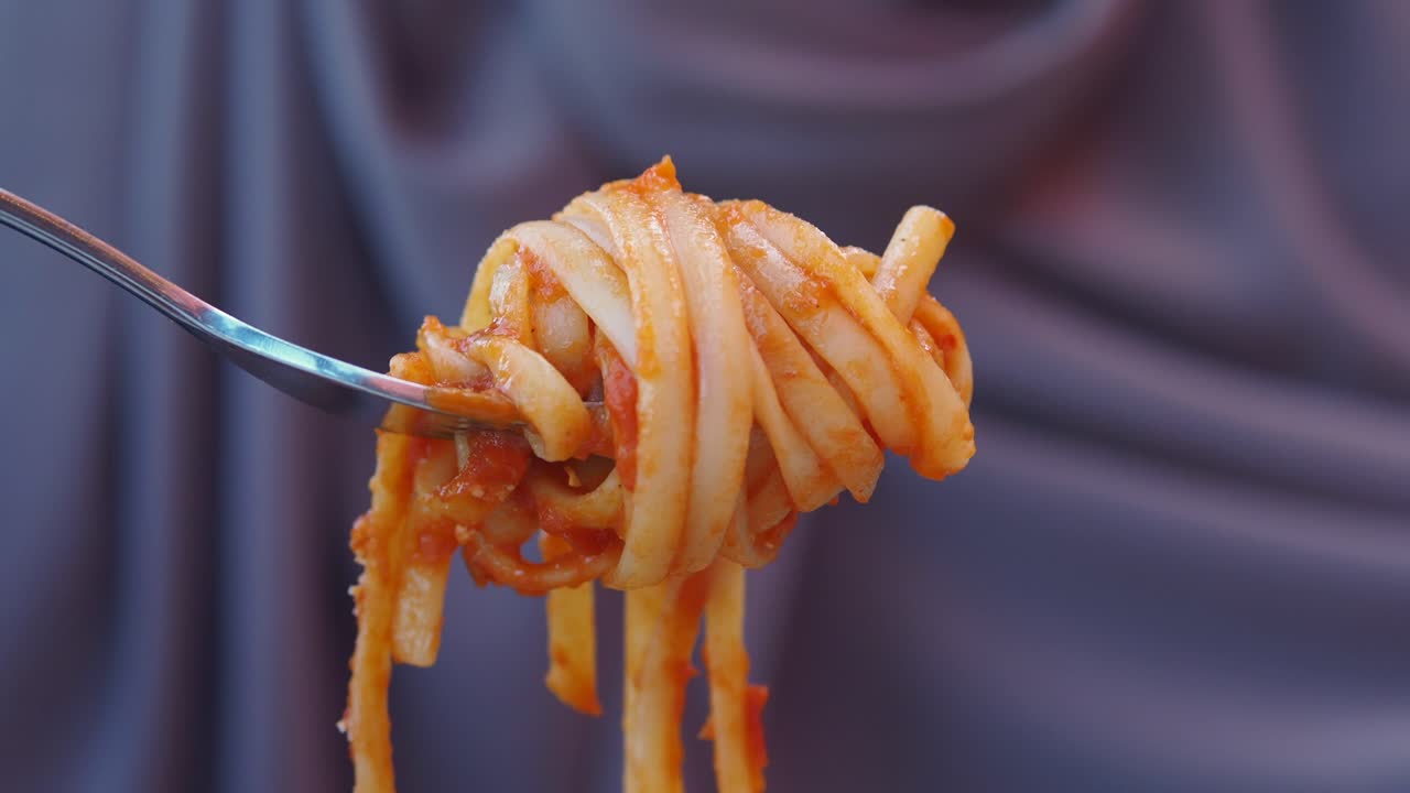 Close-up of pasta with sauce on a fork