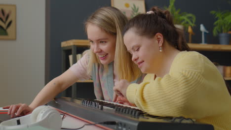 woman and girl with down syndrome playing synthesizer together