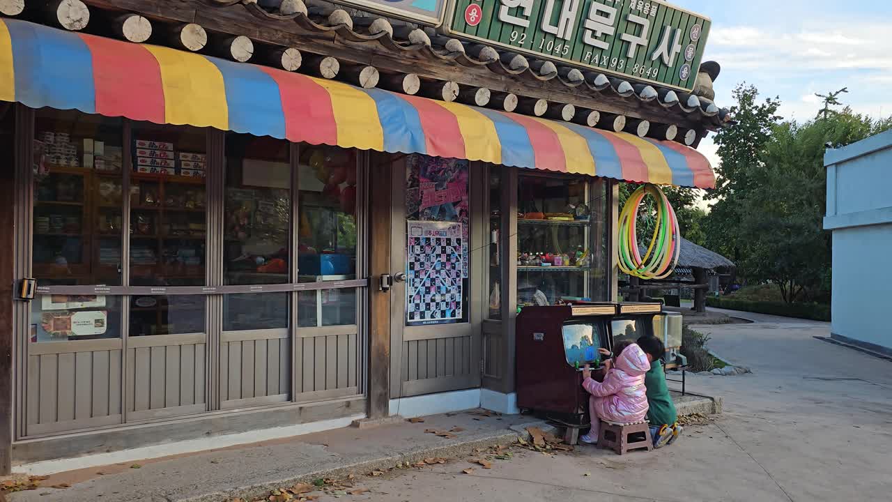 Kids Playing Old-fashioned Video Games on the Street of Memories at the National Folk Museum, Seoul, South Korea - Sideways Shot