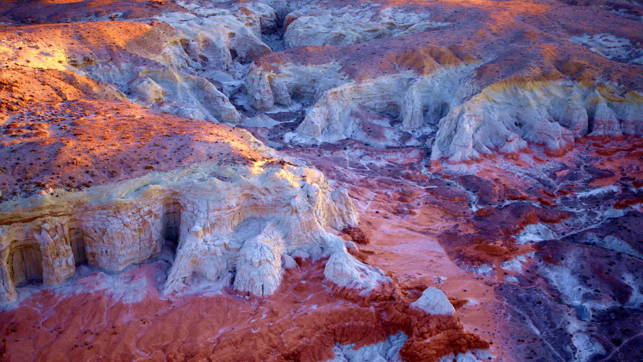 Hovering high, the drone reveals the intricate tapestry of earth and pigment across the desert floor.