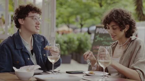 two friends enjoying an outdoor meal at a restaurant