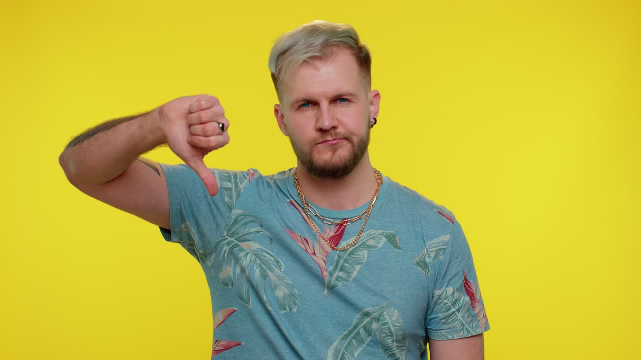 hombre molesto con una camiseta de moda mostrando los pulgares hacia abajo gesto de señal, desaprobación, disgusto insatisfecho