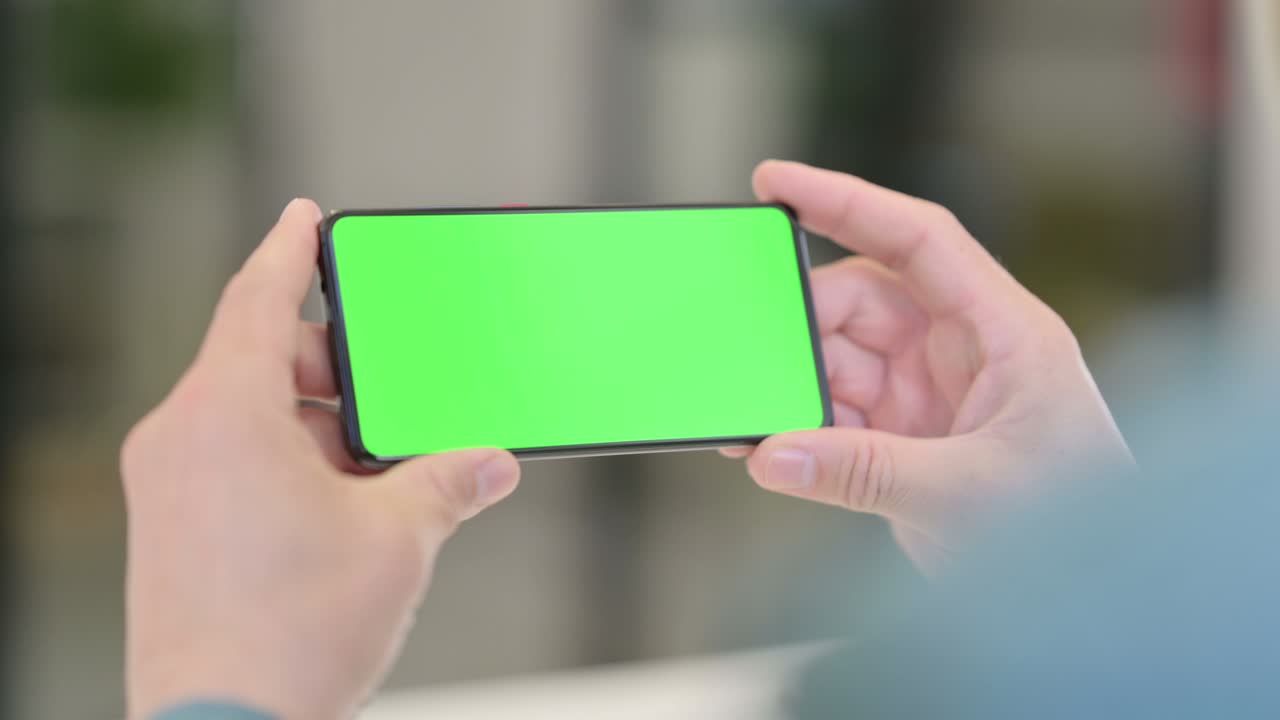 크로마 스크린 을 가진 스마트폰 을 사용하는 중년 남자