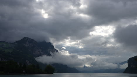 establishing shot of cloudy sky over majestic mountains and serene lake landscape