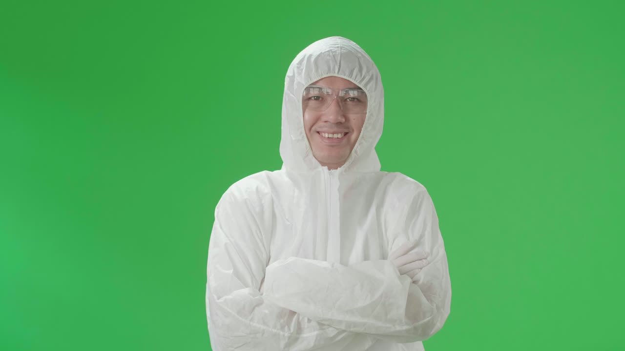 Asian Male Wearing Personal Protective Equipment Uniform Ppe Pose With Arms Crossed In Green Screen Studio
