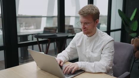 el programador está trabajando con una computadora portátil en un espacio de coworking o en una oficina escribiendo texto en el teclado enviando correos electrónicos