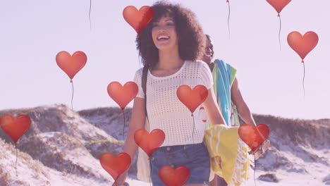 animation of hearts over happy african american couple at beach