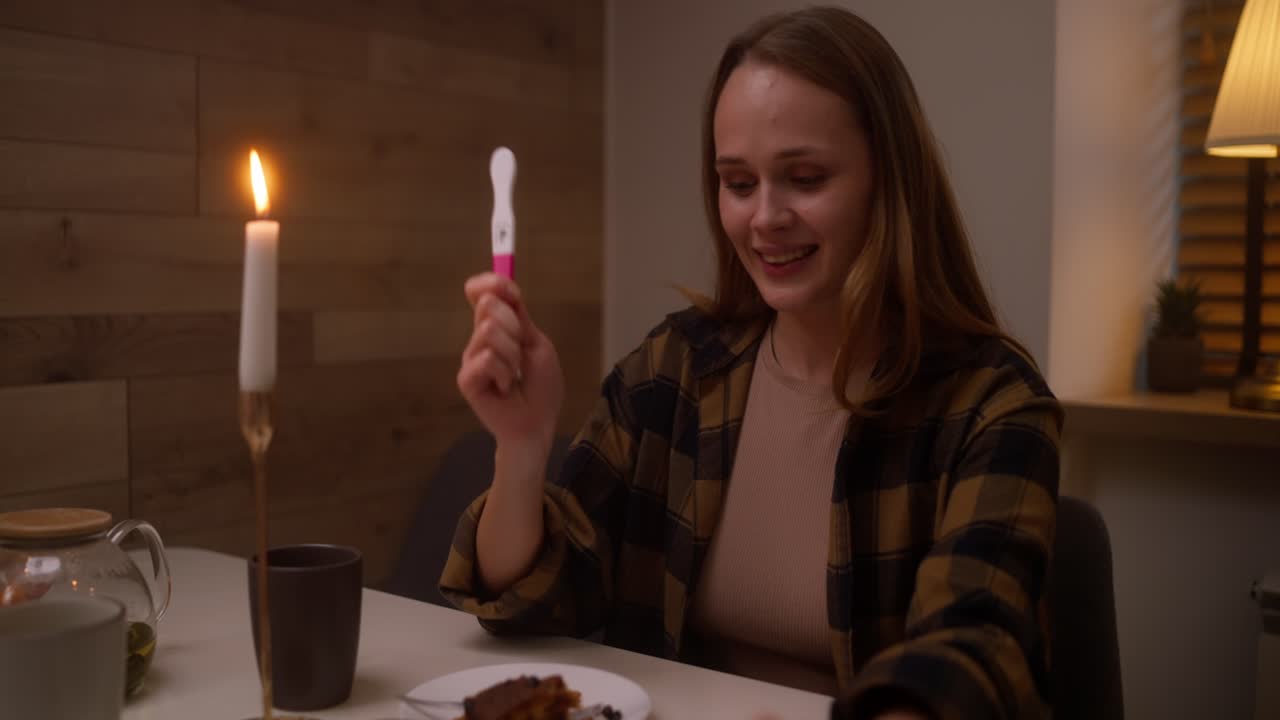 la mujer reacciona a una prueba de embarazo positiva