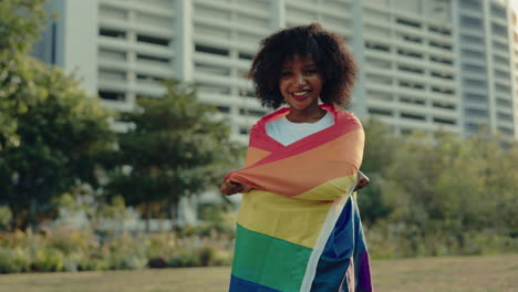 woman holding pride flag in a park