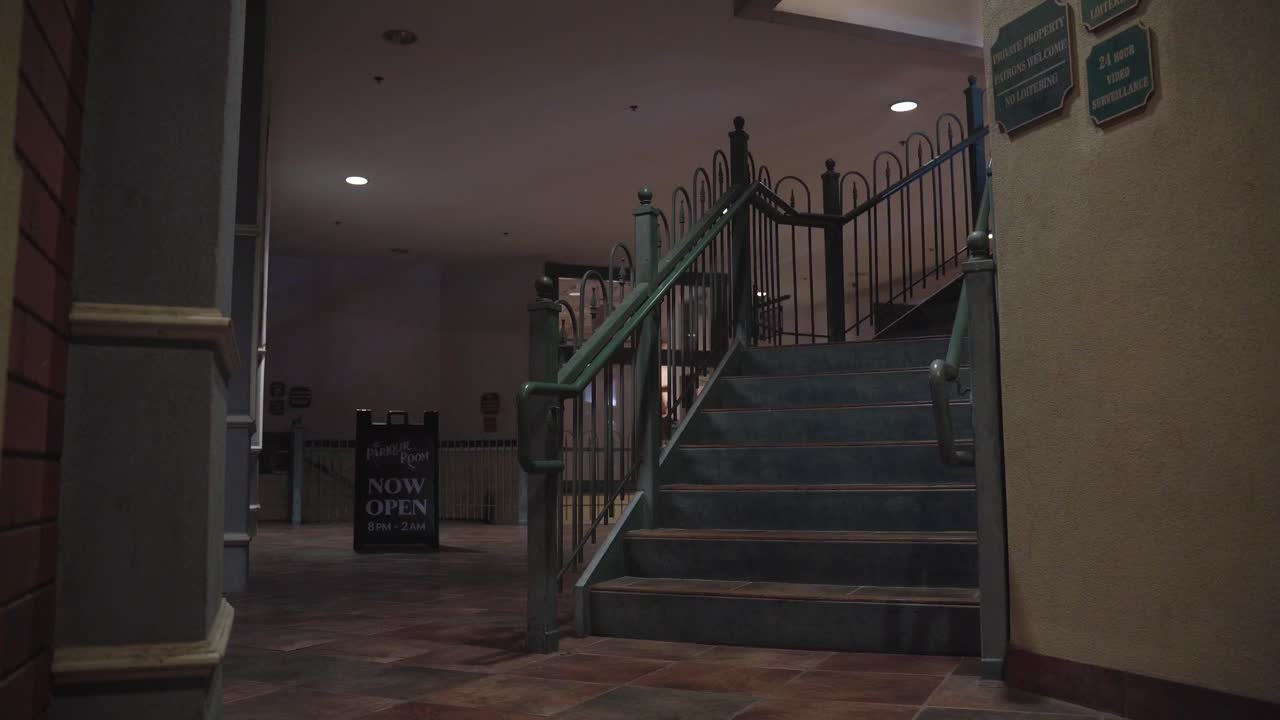 Green Stairs in a Plaza Building with a Now Open Sign