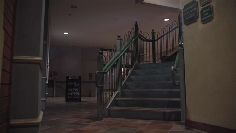 escaleras verdes en un edificio de la plaza con un cartel ahora abierto