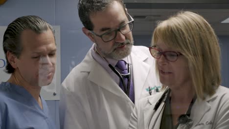 tres profesionales médicos felices y sonrientes trabajando juntos en un caso