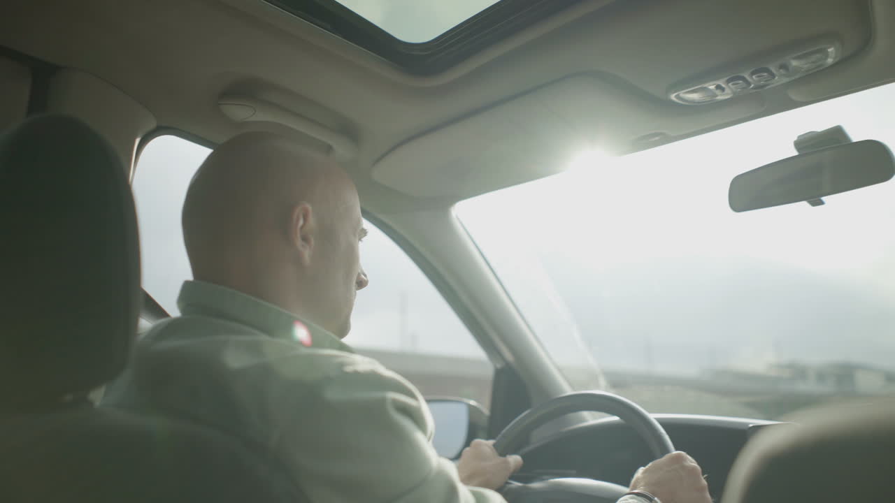 심각한 중 성인 남자가 차를 운전하고 있습니다.