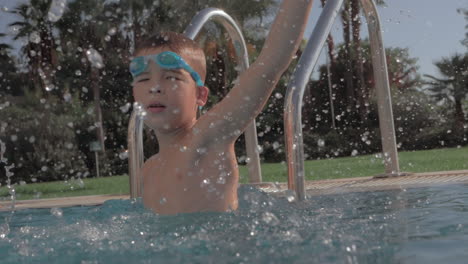 child having fun in swimming pool and splashing water