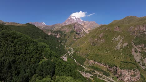 drone flying away from kazbek mountain in gergeti, georgia