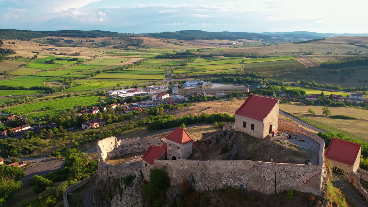 Gün batımında Rupea Kalesi’nin havadan drone ile çekilmiş görüntüsü, Romanya. Bir uçurumda yer alan kale, turistler, kasaba, yeşillik