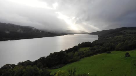 panning backwards shot of loch tummel scotland with the sun streaming through the clouds