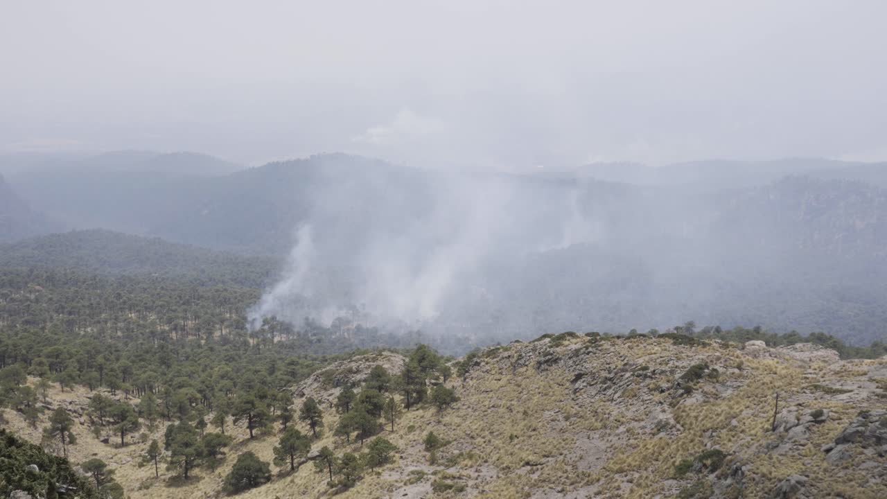 un primer plano de excursionistas hispanos sentados en la cima del monte tlaloc en un día sombrío en méxico fuego en el bosque