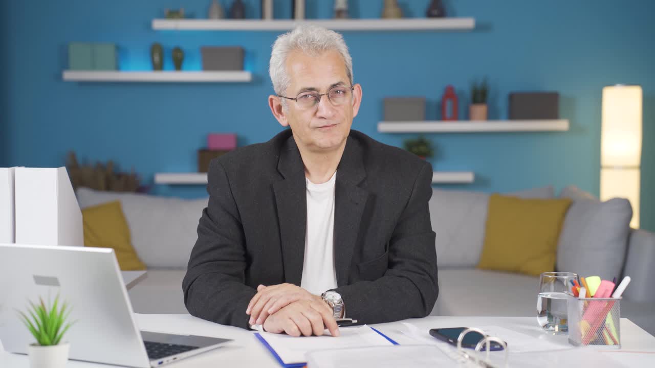 trabajador de oficina en casa mirando con complacencia a la cámara.