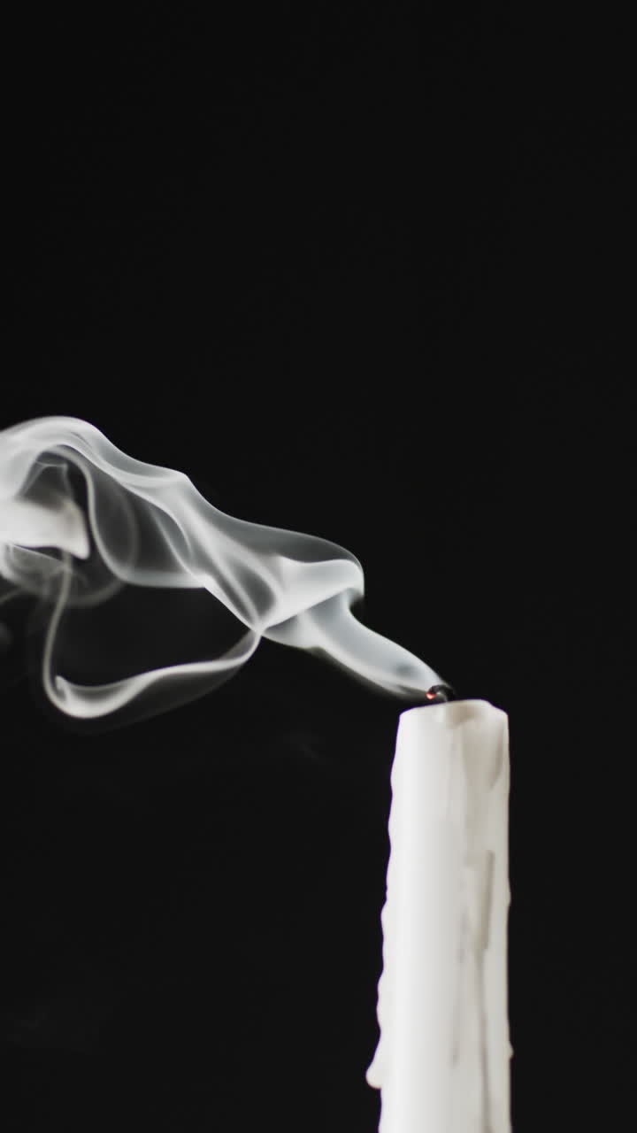 Vertical video of extinguished candle and copy space on black background