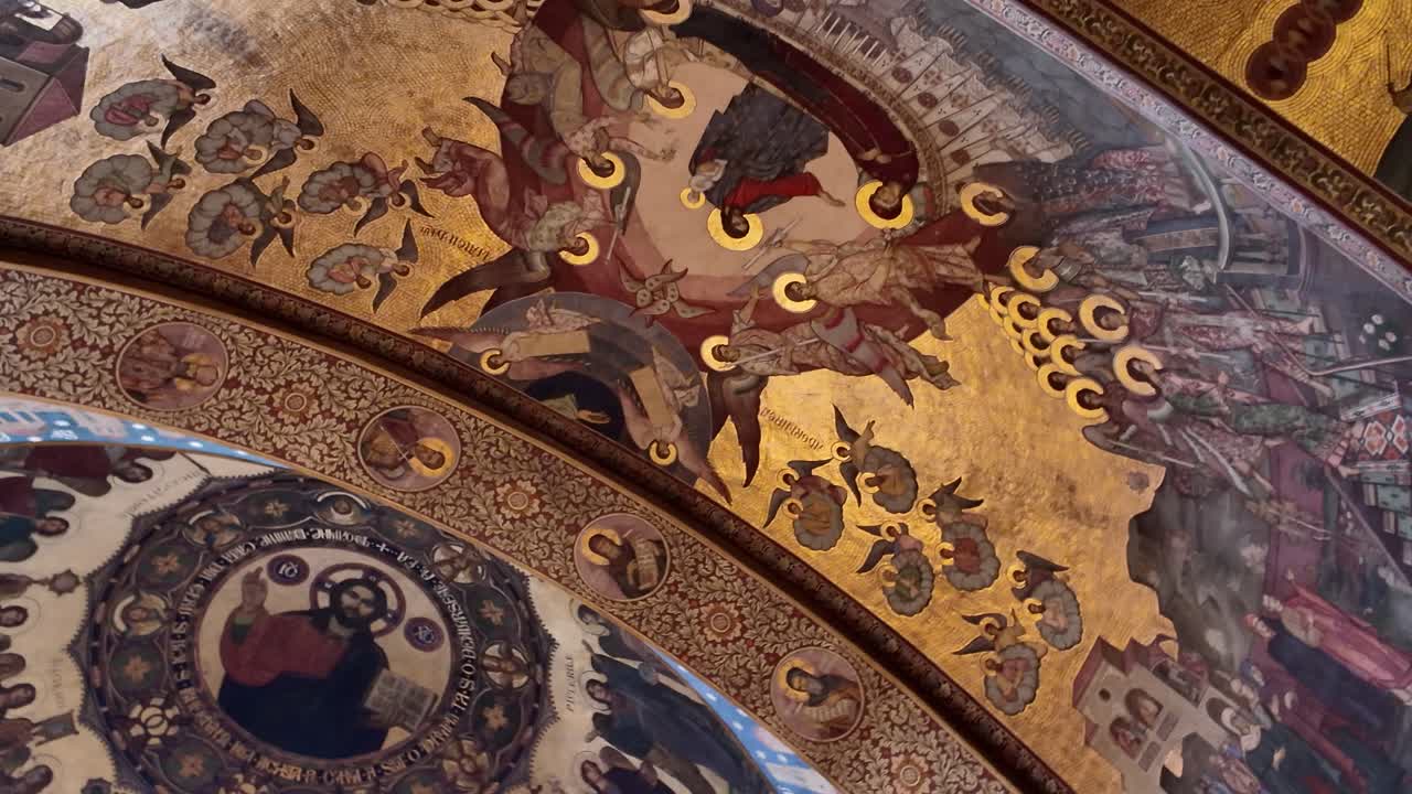 A smooth pan across the ornate ceiling of the Holy Trinity Orthodox Cathedral in Sibiu, showcasing religious frescoes with Jesus depicted at the center