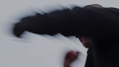 hero shot of a boxer shadowboxing against a gray sky