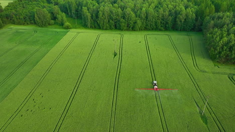 vista aérea de un campo verde con un tractor trabajando cerca de un denso bosque