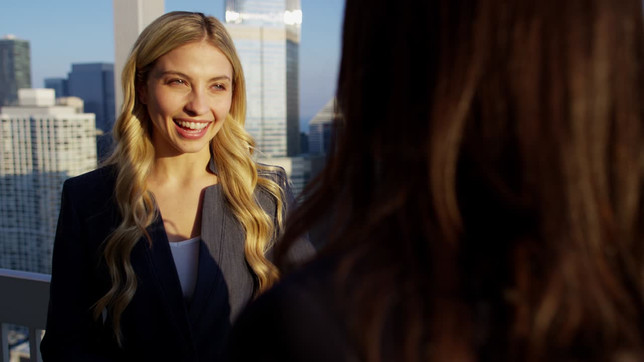 히스패닉과 백인 여성 동료들이 지붕에서 만나고 있습니다.