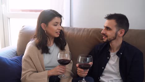 smiling couple with wineglasses at home