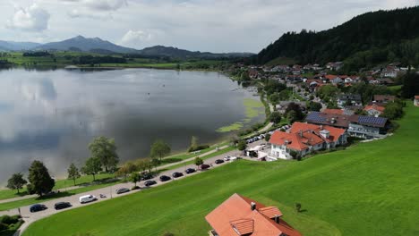 Lago-Hopfensee-Y-Ciudad-Frente-Al-Mar-Ciudad-De-Hopenfen-En-Suabia-Baviera-Alemania-Vista-Aérea-De-Drones
