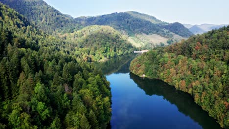 Azul-Profundo-Que-Refleja-El-Curso-Del-Río-A-Través-De-Un-Paisaje-Forestal-Montañoso-En-Un-Día-Soleado