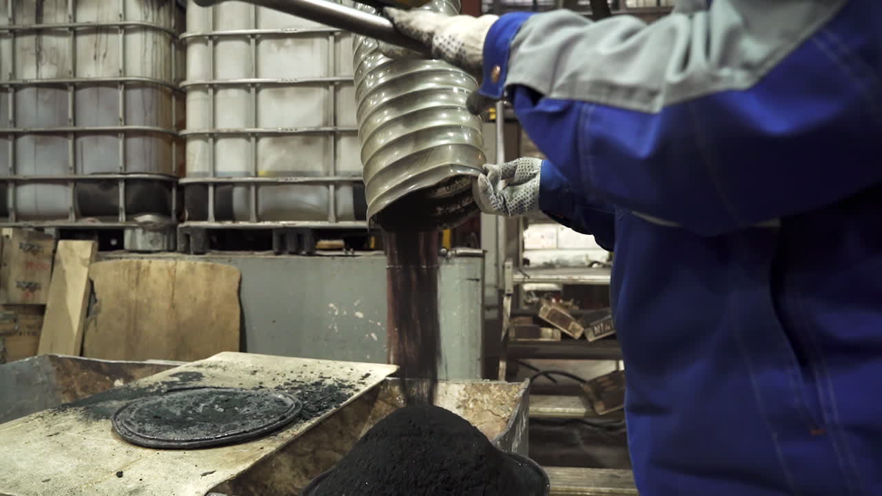 Industrial worker pouring material into container