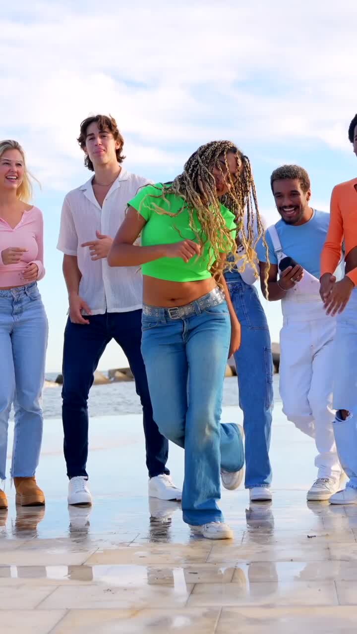 Gruppo di giovani che ballano sulla spiaggia