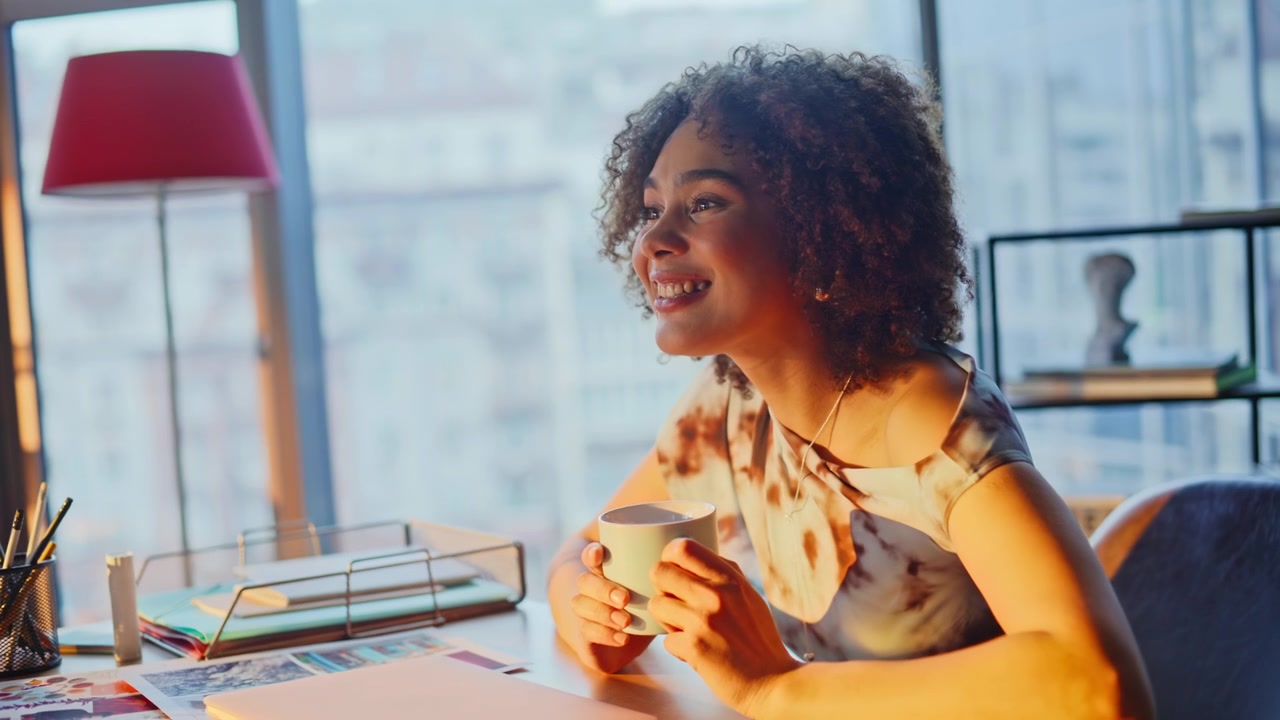 Uomo che beve caffè e parla animatamente in ufficio. Donna che ride durante una chiacchierata di lavoro