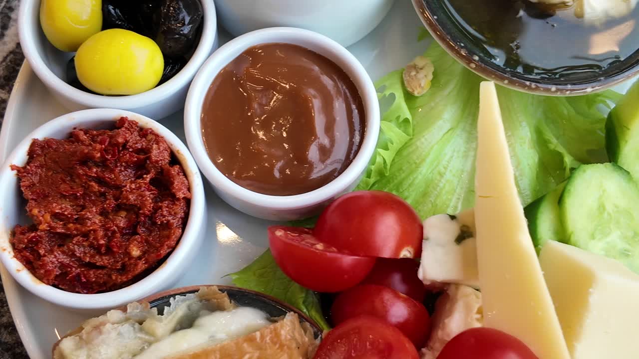 Hands Serving Fresh Cheese and Vegetables from Breakfast Platter