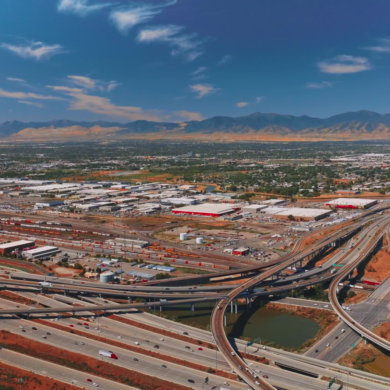 Busy road traffic at the outskirts of big city. Salt lake City, the capital of Utah State from aerial perspective. Sunny day footage