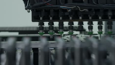 primer plano de una placa de circuitos que se ensambla en una línea de producción automatizada