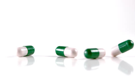 un montón de medicamentos blancos y verdes cayendo